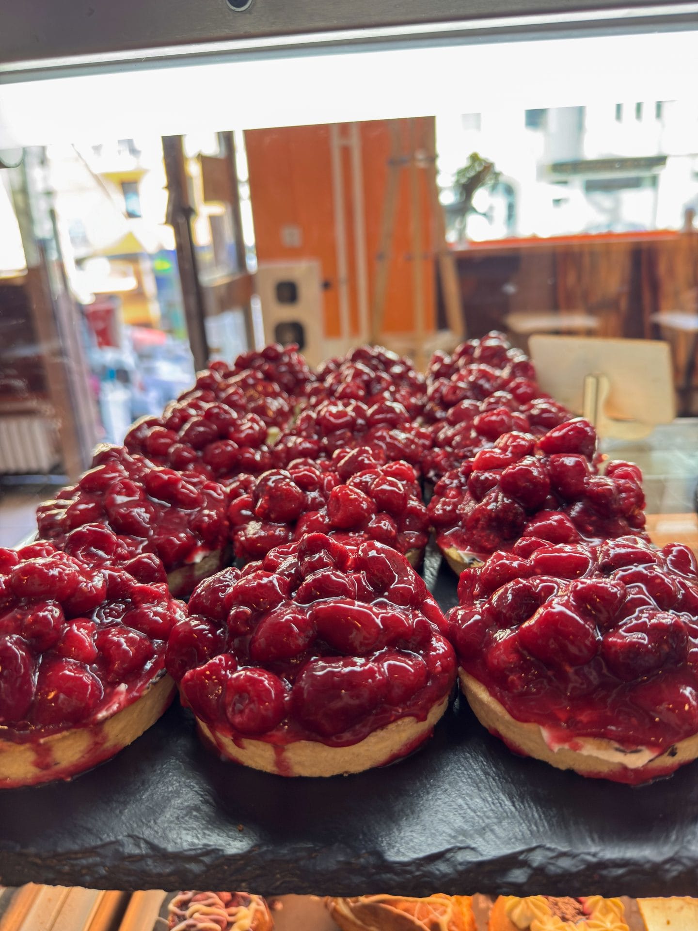 Himbeertörtchen in der Vitrine der Patisserie und Cafe Crapulix in Berlin Steglitz und Winterfeldmarkt
